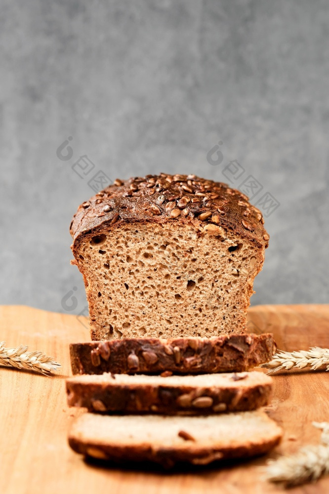 切片小麦黑麦面包切割董事会整个粮食面包与种子自然发酵自制的健康的面包