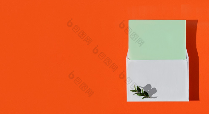 白色信封与绿色空白卡和绿色叶子烧橙色背景前视图与复制空间简约模型与信封和空白卡为祝贺你平躺