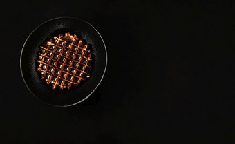 极简主义早餐的想法黑色的颜色比利时华夫饼与黑暗巧克力黑色的板甜点的想法为表格设置平躺黑色的背景前视图与复制空间