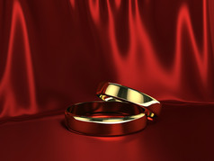 两个黄金环在红色的丝绸背景