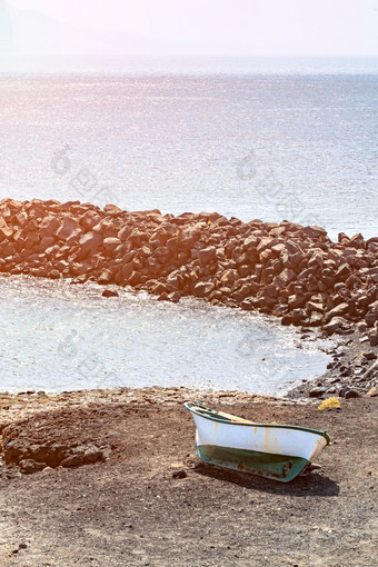 海洋岩石海岸和孤独的船附近的角有一部tenerife沃卡尼克岩石与明亮的蓝色的海波阳光明媚的一天金丝雀岛屿海洋岩石海岸和孤独的船附近的角有一部tenerife沃卡尼克岩石与明亮的蓝色的海波阳光明媚的一