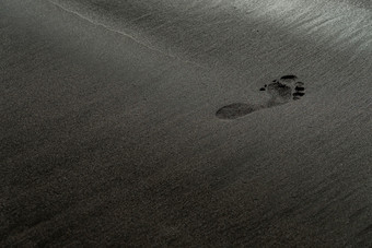 足迹黑色的沙子海滩宏摄影人类跟踪柔滑的黑色的海滩纹理与浅深度场简约黑色的背景tenerife沃卡尼克桑迪海岸足迹黑色的沙子海滩宏摄影人类跟踪柔滑的黑色的海滩纹理与浅深度场简约黑色的背景tenerife