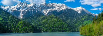 美丽的湖里察的高加索地区山绿色山山蓝色的天空与云春天景观全景美丽的湖里察的高加索地区山绿色山山蓝色的天空与云春天景观全景