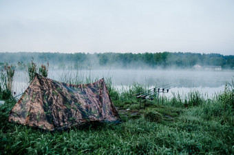 四个鲤鱼钓鱼棒杆豆荚背景湖和自然钓鱼背景鲤鱼钓鱼有雾的早....自然持有人棒野生区域伪装帐篷信号设备