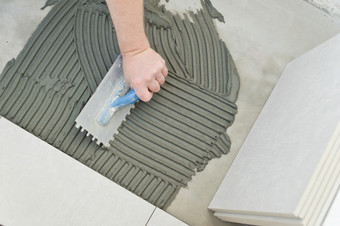 铺设陶瓷瓷砖抹灰<strong>砂浆</strong>到混凝土地板上准备为铺设白色地板上瓷砖