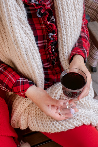 女人持有玻璃红色的酒穿着红色的和白色<strong>节日</strong>衣服女人女持有酒红色的<strong>节日</strong>衣服圣诞节新一年情人节