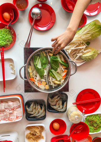 前视图新鲜切片猪肉肉与筷子在热能和蔬菜为涮和日本食物前视图肉与蔬菜在热能