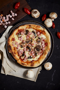 传统的意大利披萨与他和蘑菇服务板传统的意大利披萨与他和蘑菇