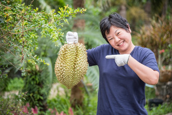 亚洲女人农民持有榴莲王水果泰国和亚洲水果有峰值壳牌和甜蜜的可以买泰国街食物和水果市场农业农场亚洲农民持有榴莲王水果