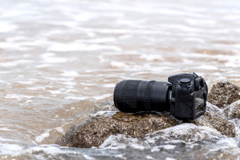 数码单反相机相机与长焦镜头湿从水海波石头海滩当旅行和测试使用的极端的环境<strong>演示</strong>防水<strong>摄影</strong>师数码单反相机相机石头海滩湿从水海波