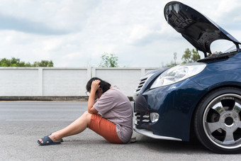 亚洲女人独自一人司机检查车引擎为修复和修复问题与不开心和惨淡的之间的等待车机械师从车引擎问题路边女人不开心和惨淡的从车引擎问题