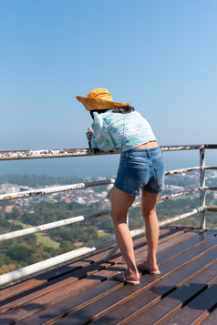 亚洲漂亮的可爱的女人与他放松和使用智能手机海边城市景观的观点山与快乐和自由情感概念旅行假期休闲生活女人放松景观的观点山