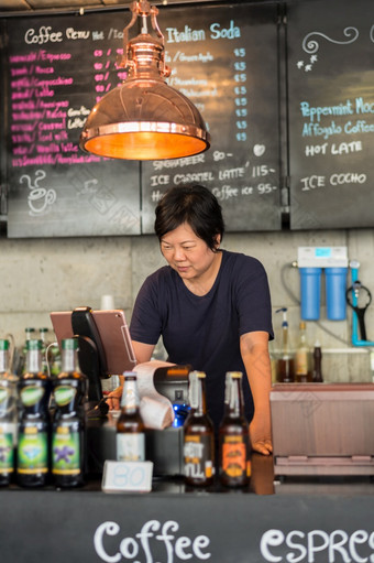 亚洲女人白色皮肤丰满身体咖啡商店老板工作收银员服务客户的咖啡商店咖啡馆亚洲女人工作收银员服务咖啡商店
