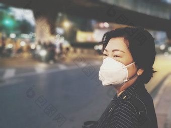 亚洲女人使用面具呼吸保护面具对空气与<strong>烟雾灰尘</strong>超过的标准价值曼谷城市与坏天气空气污染路与交通曼谷女人使用面具保护<strong>烟雾灰尘</strong>城市