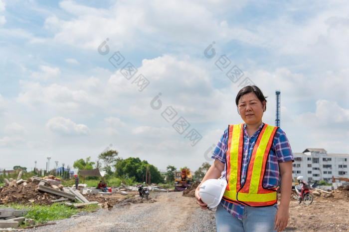 亚洲女人民事建设工程师工人架构师与头盔和安全背心快乐工作建筑建设网站女人建设工程师建设网站