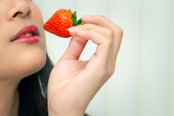 亚洲漂亮的女人持有和吃新鲜的草莓红色的浆果水果颜色和甜蜜的多汁的与享受和快乐情感概念食物健康的吃生活女人吃草莓红色的浆果水果甜蜜的多汁的