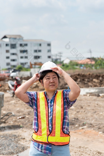 亚洲女人民事建设工程师工人架构师与头盔和安全背心快乐工作建筑建设网站女人建设工程师建设网站