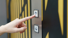 女人手指紧迫的按钮电梯按钮内部的建筑