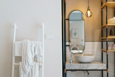 现代浴室镜子与发光的灯和水槽毛巾架楼梯