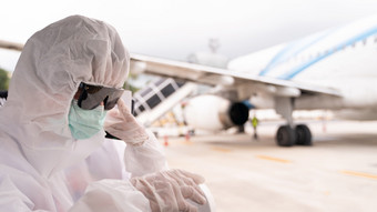 人穿保护西装佩普与面具坐公共汽车进入飞机停车外终端机场在新冠病毒病毒流感大流行安全旅行概念