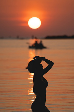 日落海洋视图太阳以上的海橙色天空女人站海滩