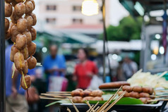烤泰国大米和猪肉香肠挂前面摊位和躺香蕉叶子街食物市场黄昏泰国焦点香肠挂