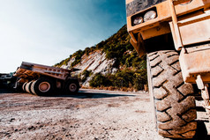 特写镜头大轮矿业转储卡车开放坑附近山区域很多大矿业转储卡车停的背景工业运输概念焦点轮
