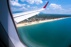 空中视图热带海滩阳光明媚的夏天视图从飞机窗口