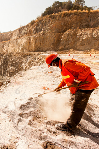 确认矿业公司穿脸面具头盔和保护设备工作与矿业工具尘土飞扬的和烘焙热矿业采石场工作行业概念
