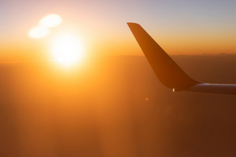 神奇的时间风景优美的视图从飞机窗口座位的太阳设置轻轻云和天际线的翼的飞机的射线日落光明亮的和色彩斑斓的夏天季节旅行旅程
