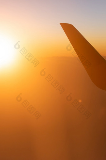 神奇的时间风景优美的视图从飞机窗口座位的太阳设置轻轻云和天际线的翼的飞机的射线日落光明亮的和色彩斑斓的夏天季节旅行<strong>旅程</strong>
