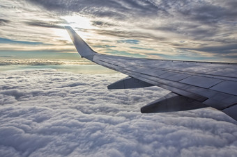 日落多云的天空而且飞机翼见过通过窗口飞机