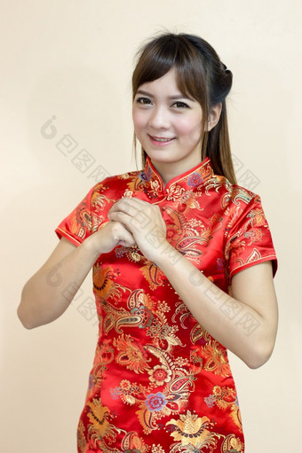 亚洲女人问候传统的中国人旗袍与手电梯欢迎表达式和幸运的中国人新一年庆祝活动红色的金风格