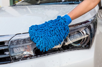 女人手与蓝色的超细纤维织物洗头灯现代<strong>车清洁</strong>汽<strong>车车</strong>洗概念