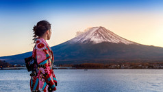 亚洲女人穿日本传统的和服富士山日落河口湖湖日本