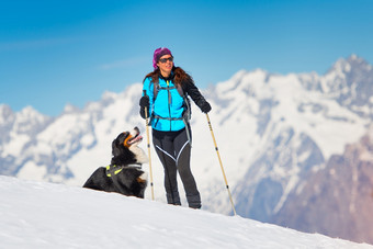 登山家女孩滑雪板和海豹皮独自一人与他的狗忠实的朋友