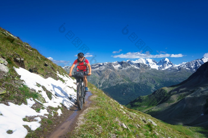 骑摩托车的人山小道美丽的景观的阿尔卑斯山脉