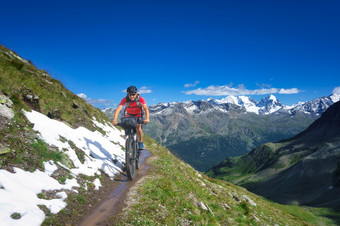 骑摩托车的人山小道美丽的景观的阿尔卑斯山脉