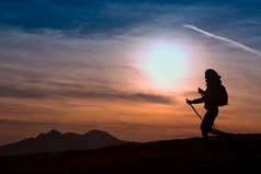 女人徒步旅行的山日落户外冒险活跃的生活方式