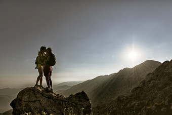 接吻夫妇登山者的峰会的山日落