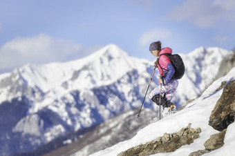 女人登山者下坡与鞋雪坡