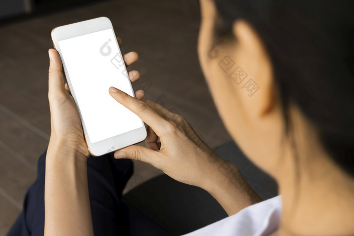 特写镜头女人手举行与聪明的电话白色屏幕沙发的生活房间概念技术连接沟通