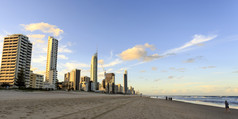 走的海滩日落有的摩天大楼的背景