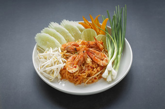 垫泰国pud泰国搅拌炸面条与虾服务与绿豆豆发芽黄瓜石灰辣椒和春天洋葱