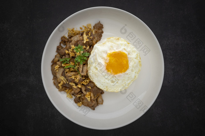 考县MOO芯片芯片克拉蒂亚姆或道泰国食物流大米超过与炸猪肉与大蒜和炸蛋陶瓷板黑暗灰色纹理背景