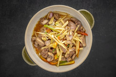 kruang奈盖垫王泰国食物搅拌炸鸡内脏各种肉摘下器官肉与姜陶瓷碗黑暗语气纹理背景前视图