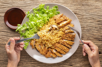 搅拌炸即时面条与日本深炸猪肉肉片炸猪排生菜和香菇蘑菇旁边炸猪排酱汁超过与白色<strong>芝麻</strong>乡村木纹理背景前视图