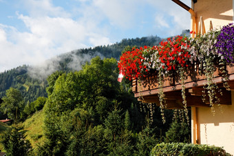 高山的小木屋阳台与花绿色山背景高山的小木屋阳台与花绿色山背景