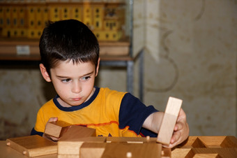 可爱的小男孩戏剧与木砖而且构建房子可爱的小男孩戏剧与木砖在室内而且构建房子
