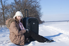 青少年女孩与手提箱在户外冬天时间